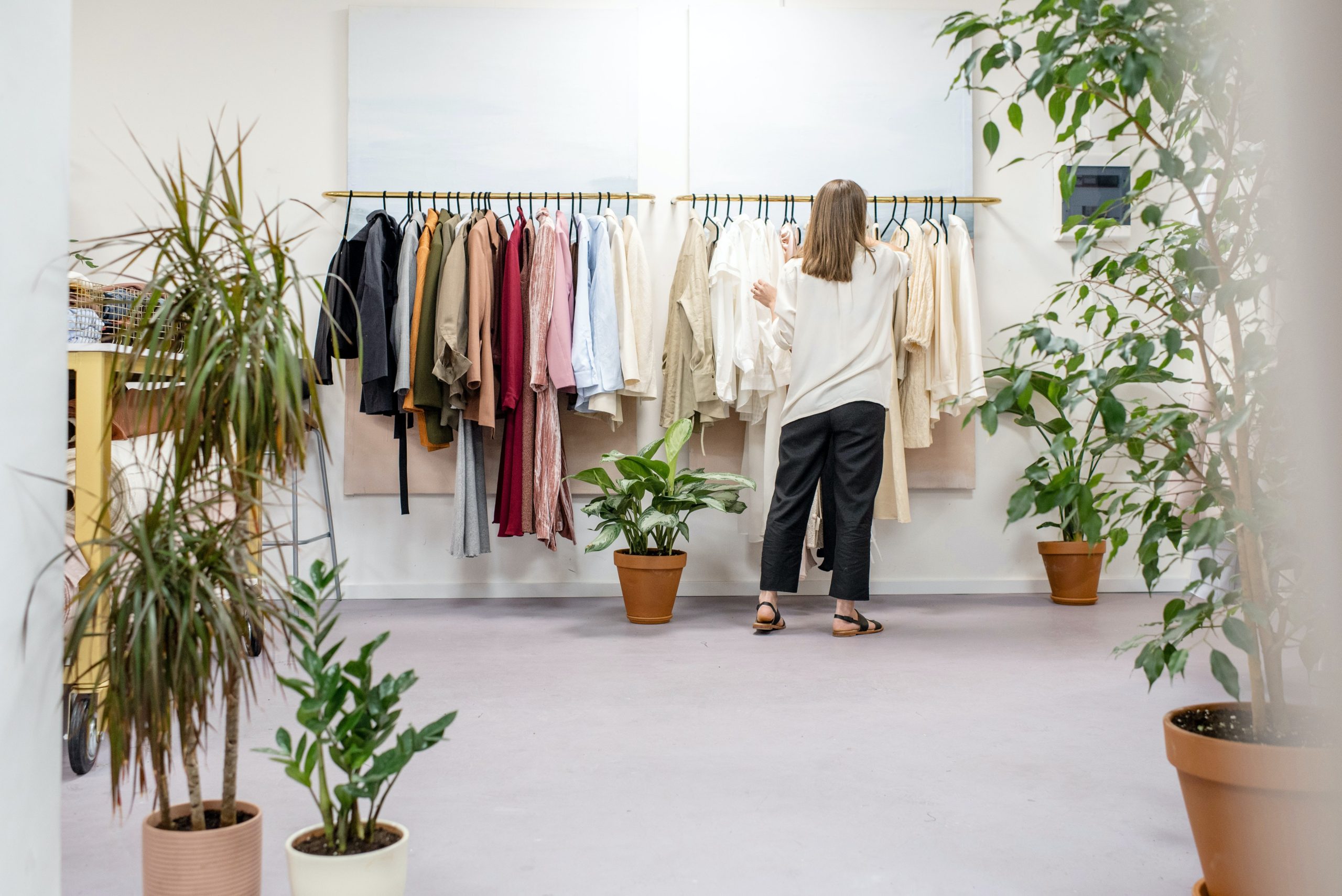 Lady standing in front of a clothes rail arranging the clothes