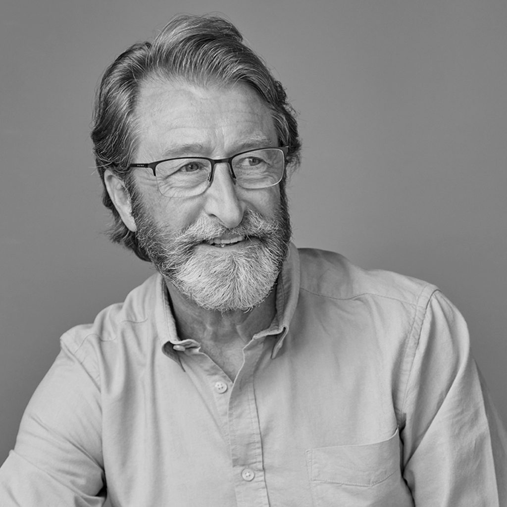Man with white beard and glasses wearing smart shirt for business headshot