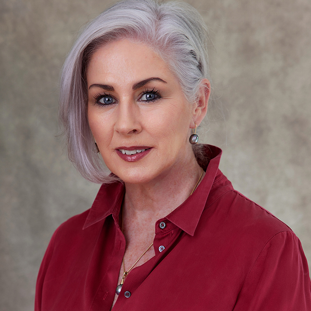 Middle age lady with white hair wearing silk red blouse for business headshot